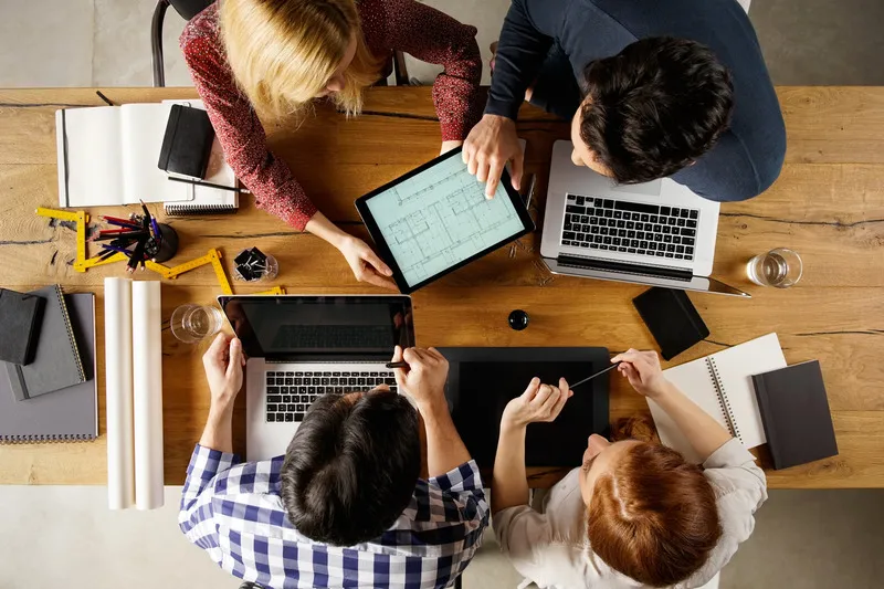 Arbeitsgruppe an einem Tisch mit Laptops, Lehrtätigkeit